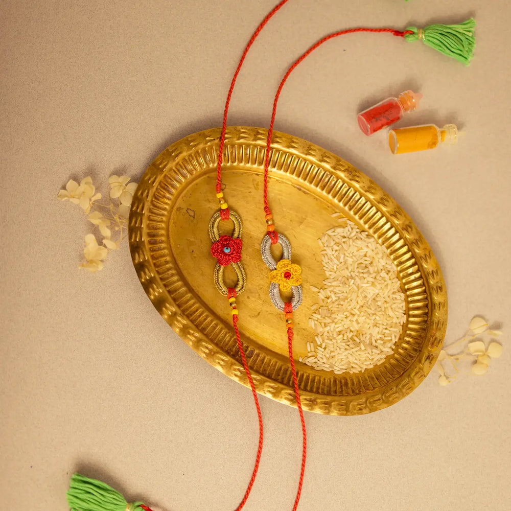 Handmade Crochet Ananta Rakhi With Roli Chawal Set Of 2 1 - Flat lay with decorative elements