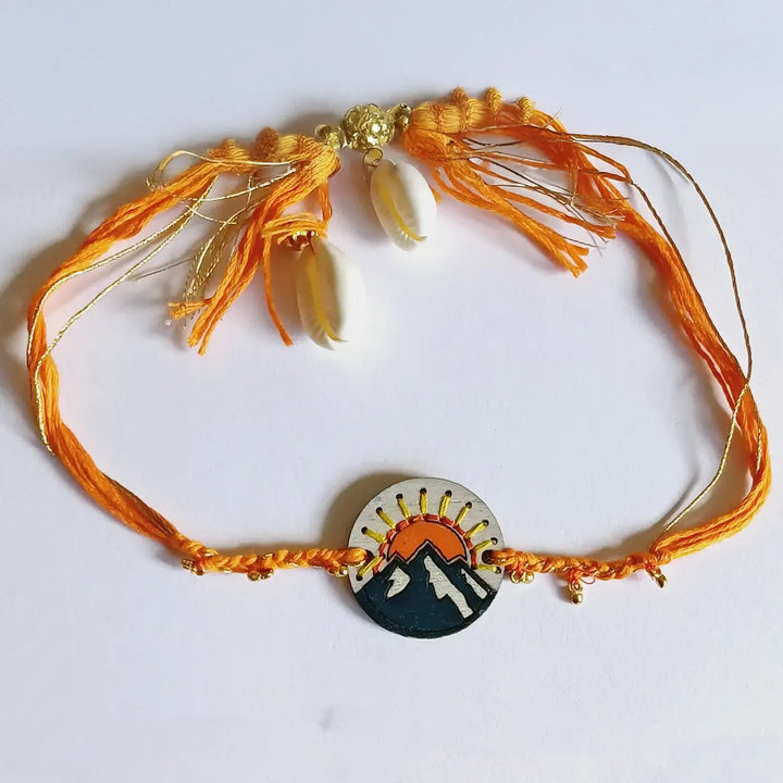 Handmade Blue Mountain Snow Design Ghungroo & Shell Wooden Lumba Rakhi For Bhabhi With Roli Chawal