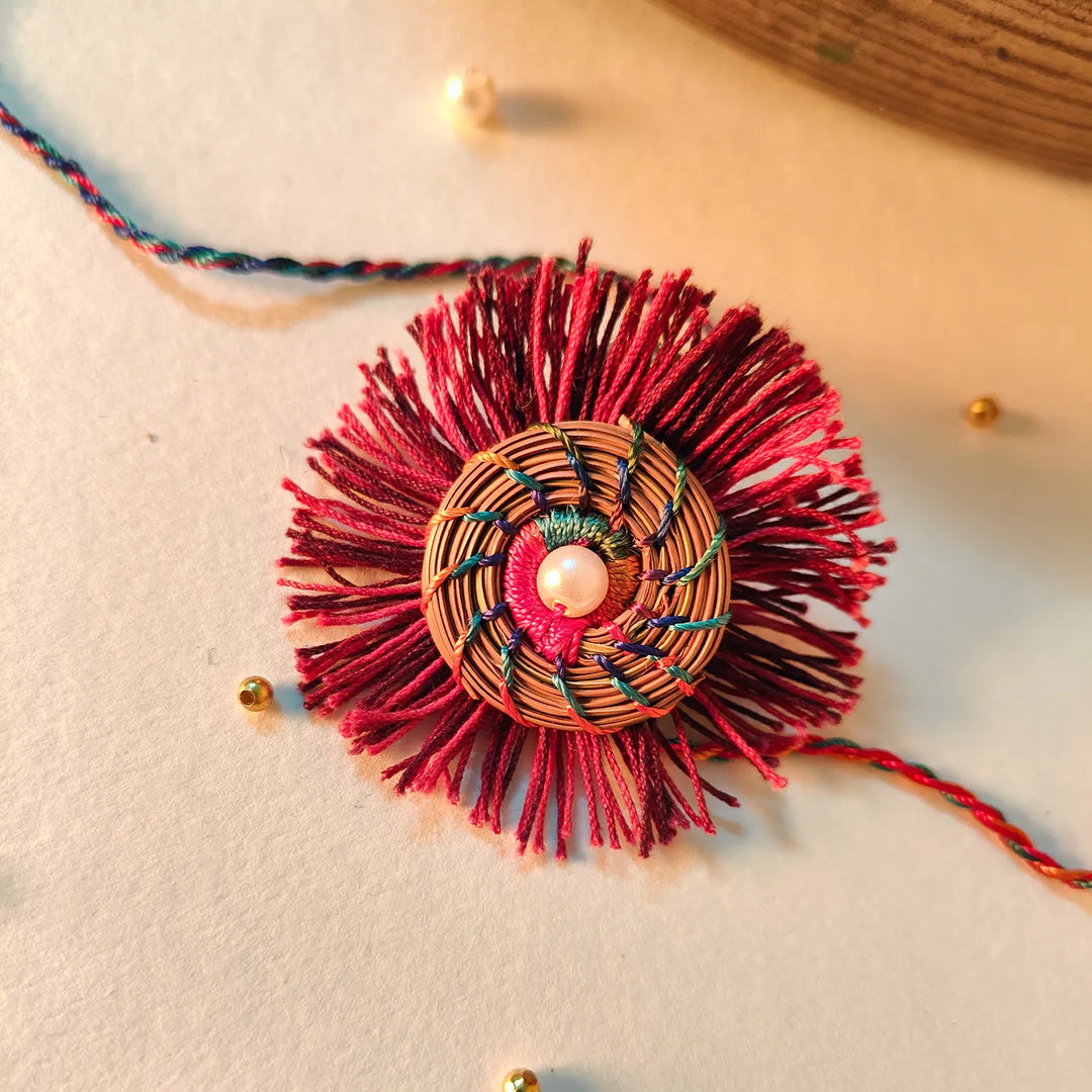 Eco Friendly Handmade Red And Pink Pine Needle Rakhi With Pouch And Roli Chawal - Top View Close-up