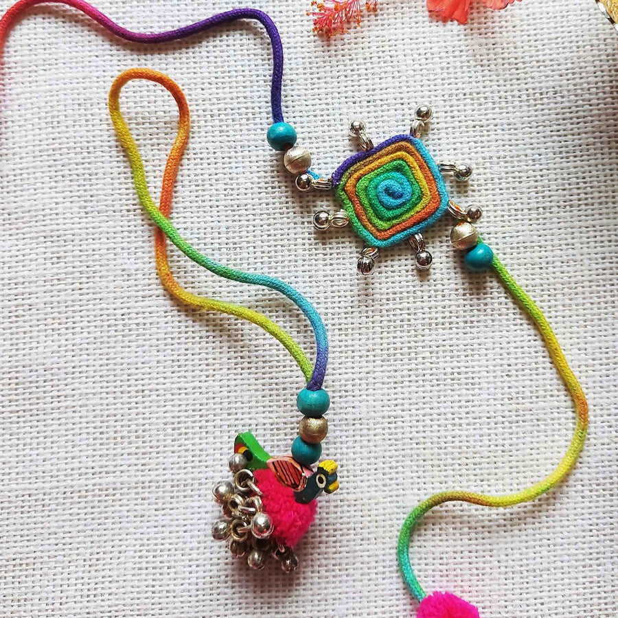 Handmade Dori Work Peacock And Ghungroo Bhaiya Bhabhi Rakhi With Roli Chawal Set Of 2 - Close-up of both ornament charms