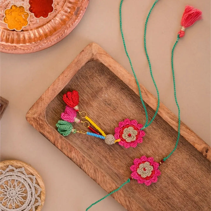 Handmade Crochet Pink Bougainvillea Bhaiya Bhabhi Rakhi With Roli Chawal Set Of 2 - Overhead View with Accessories