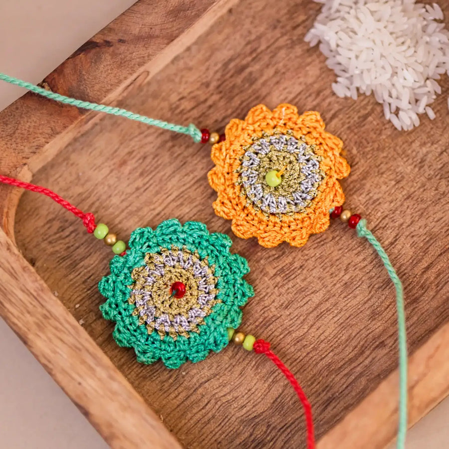 Handmade Crochet Green And Yellow Seher Rakhi With Roli Chawal Set Of 2 - Close-up of Crochet Rakhi Pair