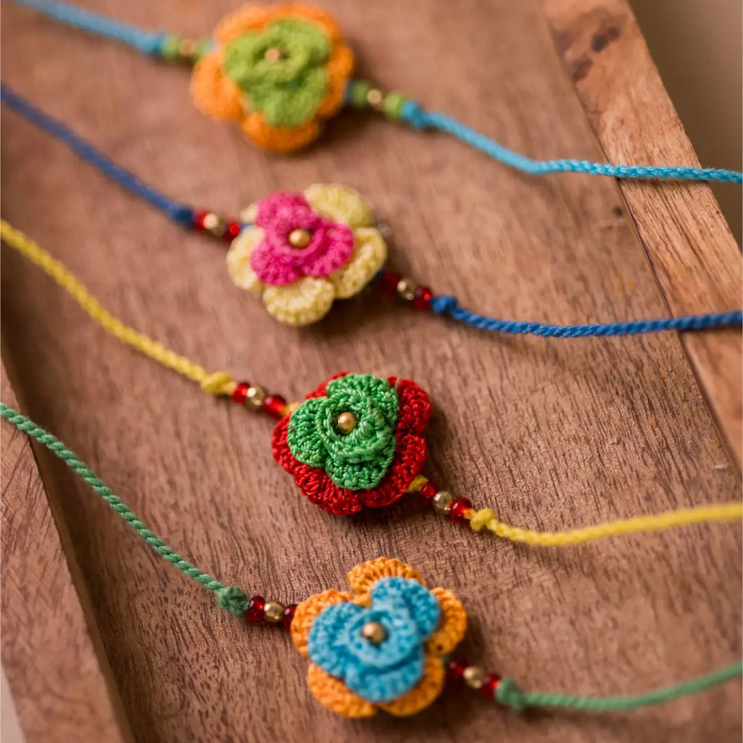 Handmade Crochet Multicolor Roses Rakhi With Roli Chawal Set Of 4 - Angled Close-up Display
