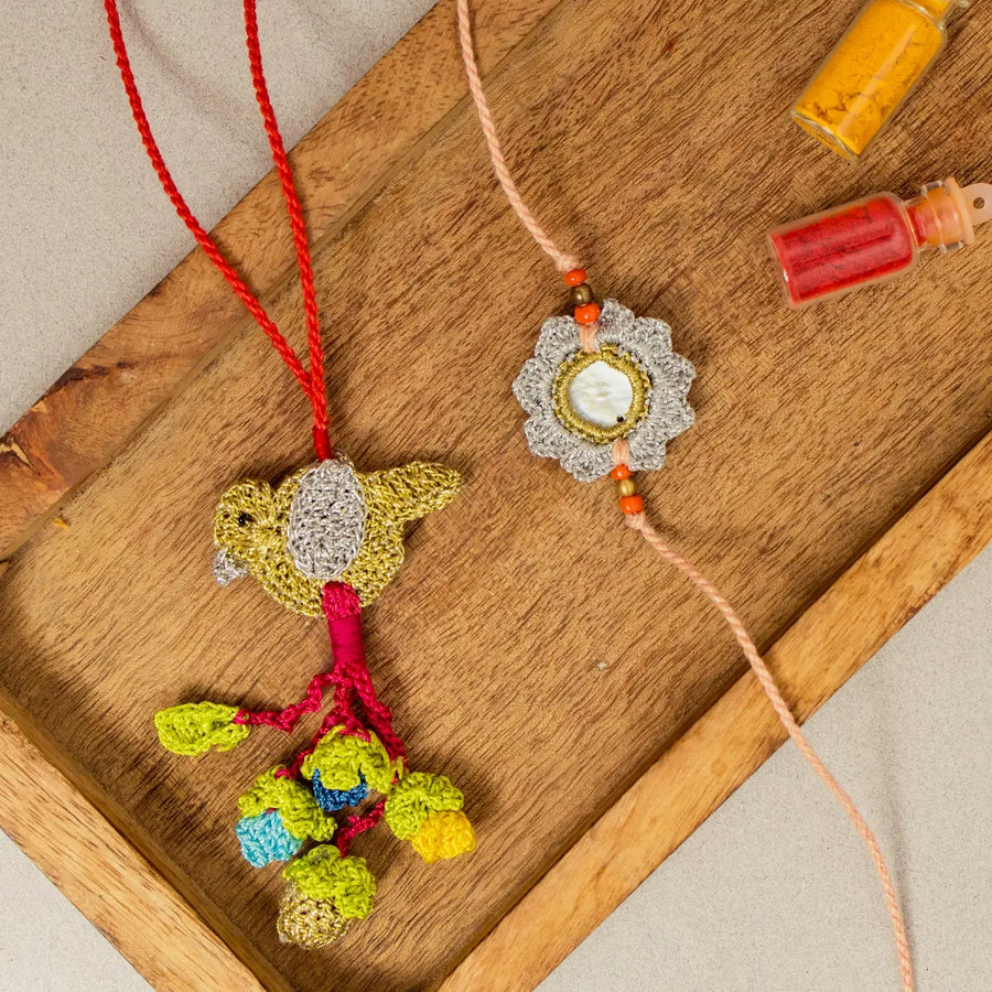 Handmade Crochet Paakhi Seepi Bhaiya Bhabhi Rakhi With Roli Chawal Set Of 2 - Flat Lay Display on Wooden Tray