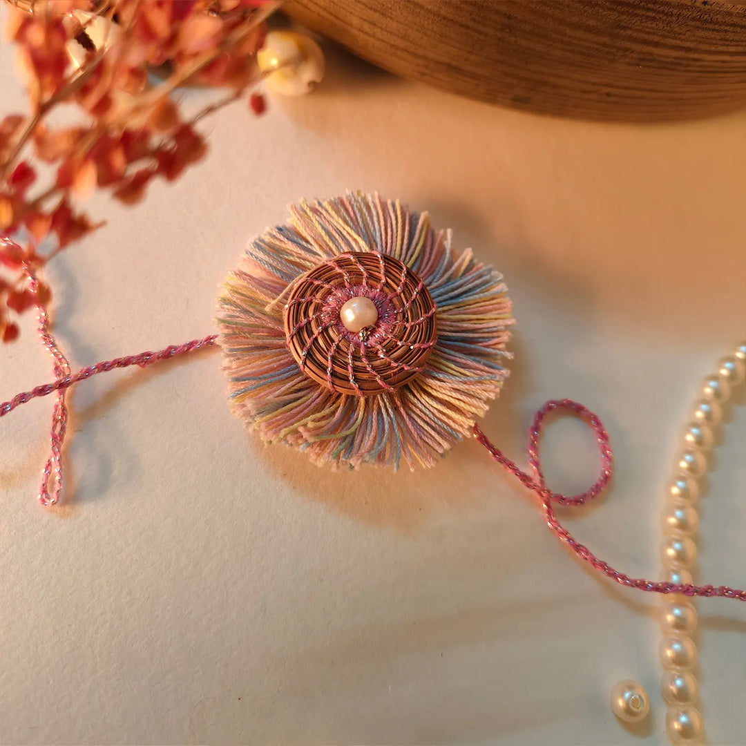 Eco Friendly Handmade Pastel Colour Pine Needle Rakhi With Pouch And Roli Chawal - Close-up with Pearl Necklace