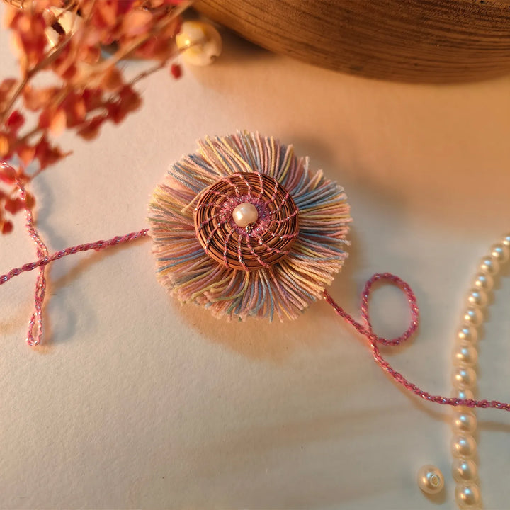 Eco Friendly Handmade Pastel Colour Pine Needle Rakhi With Pouch And Roli Chawal - Close-up with Pearl Necklace