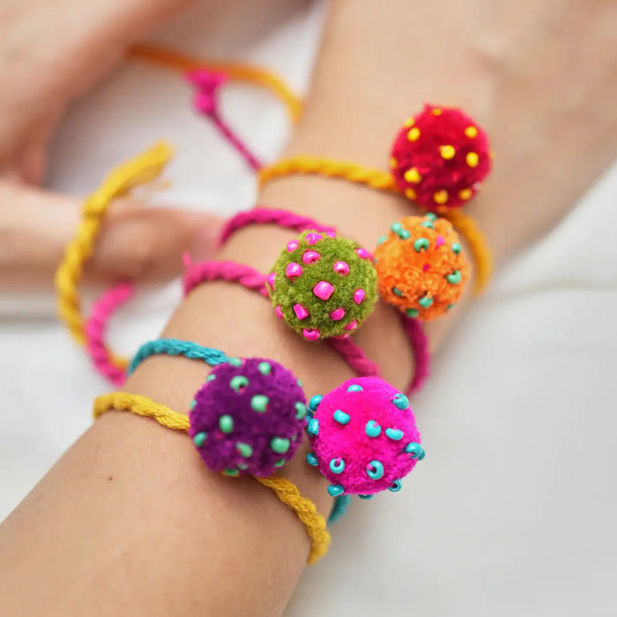 Handmade Beaded Pom Pom Mini Laddoo Rakhi With Roli Chawal Set Of 5 - Close-up of bracelets on wrist