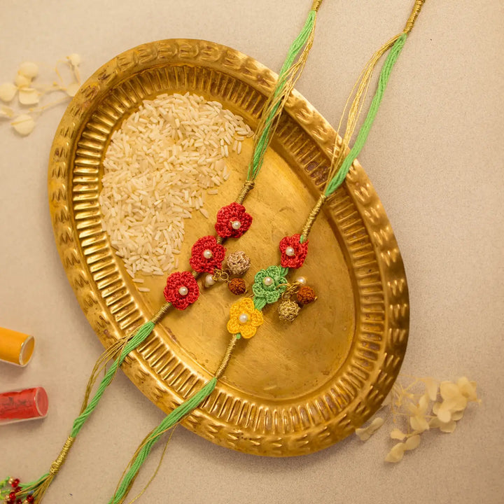 Handmade Crochet Ananya Phool And Rudraksh Rakhi With Roli Chawal Set Of 2 - Top View of Rakhis with Rice