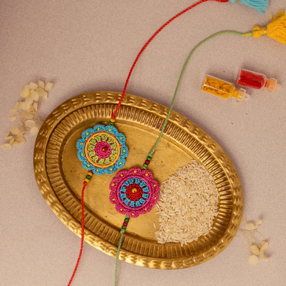 Handmade Crochet Floral Noor Rakhi With Roli Chawal Set Of 2 - Top View with Decorative Items