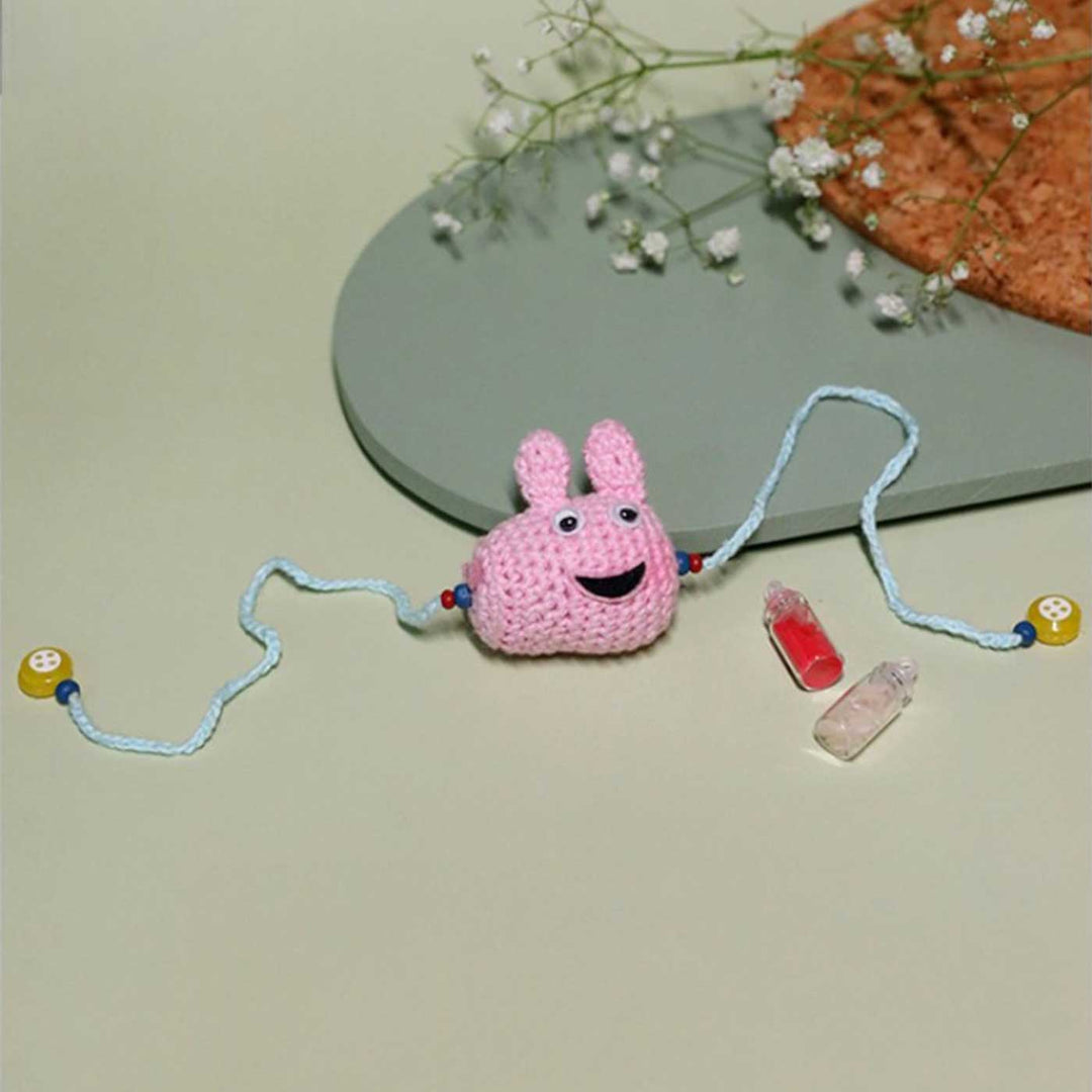 Handmade Crochet Peppa Pig Kids Lumba Rakhi With Roli Chawal - Flat Lay Showing Full Length
