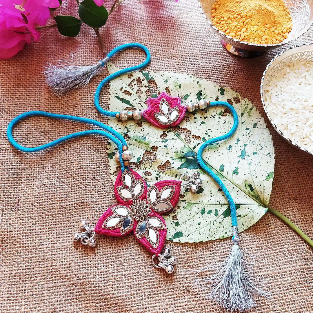 Handmade Mirror Work Lotus Bhaiya Bhabhi Rakhi With Roli Chawal Set Of 2 - Styled Flat Lay Arrangement