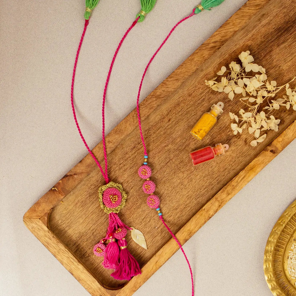 Handmade Crochet Gulabi Jhalar Bhaiya Bhabhi Rakhi With Roli Chawal Set Of 2 - Flat Lay of Two Necklaces