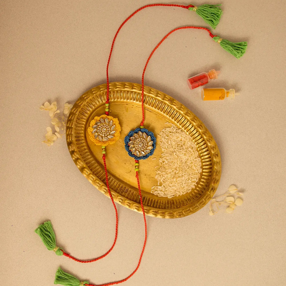 Handmade Crochet Blue And Yellow Kundan Rakhi With Roli Chawal Set Of 2 - Top View with Decorative Items
