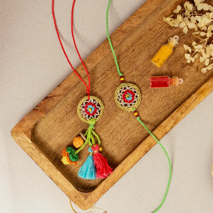 Handmade Crochet Gold Dreamcatcher Bhaiya Bhabhi Rakhi With Roli Chawal Set Of 2 - Top View on Tray with Bottles
