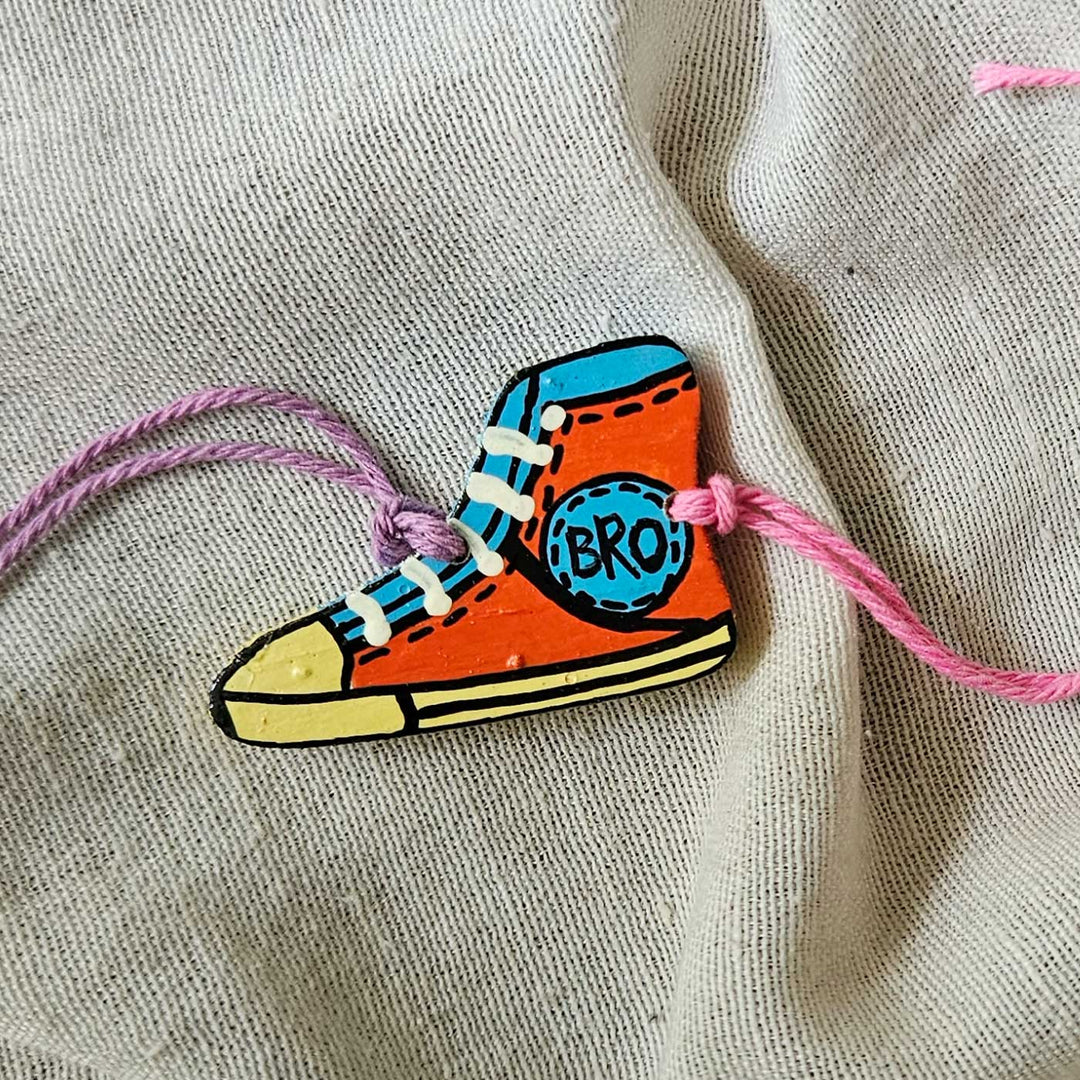 Handpainted Quirky Wooden Rakhi With Roli Chawal 12 - Close-up of single orange shoe rakhi