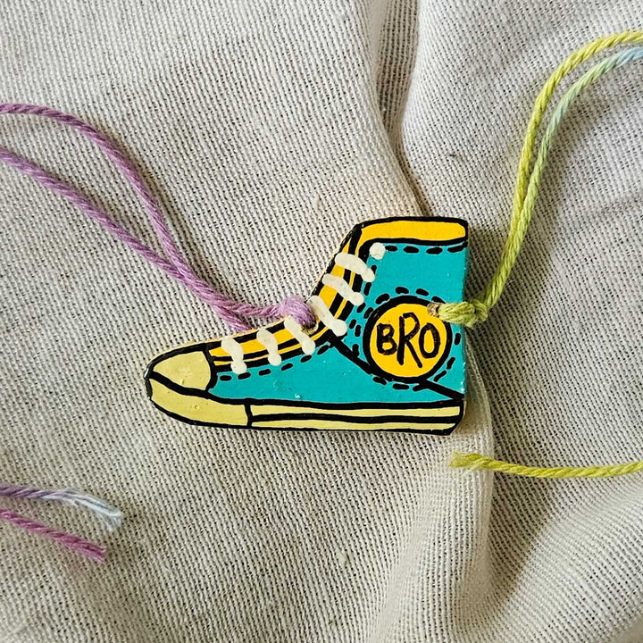Handpainted Quirky Wooden Rakhi With Roli Chawal 12 - Close-up of single shoe rakhi