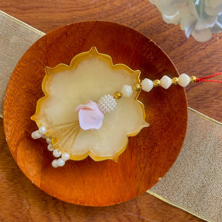 Handmade White And Gold Flower Design Pearl And Stone Bhaiya Bhabhi Rakhi - Partial view with floral detail