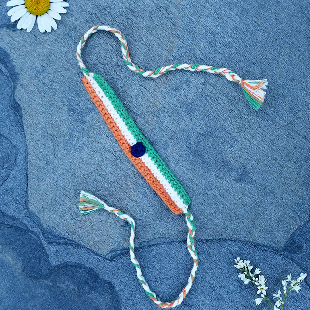 Handmade Crochet Indian Flag Band Rakhi With Roli Chawal - Flat Lay with Flower Accents