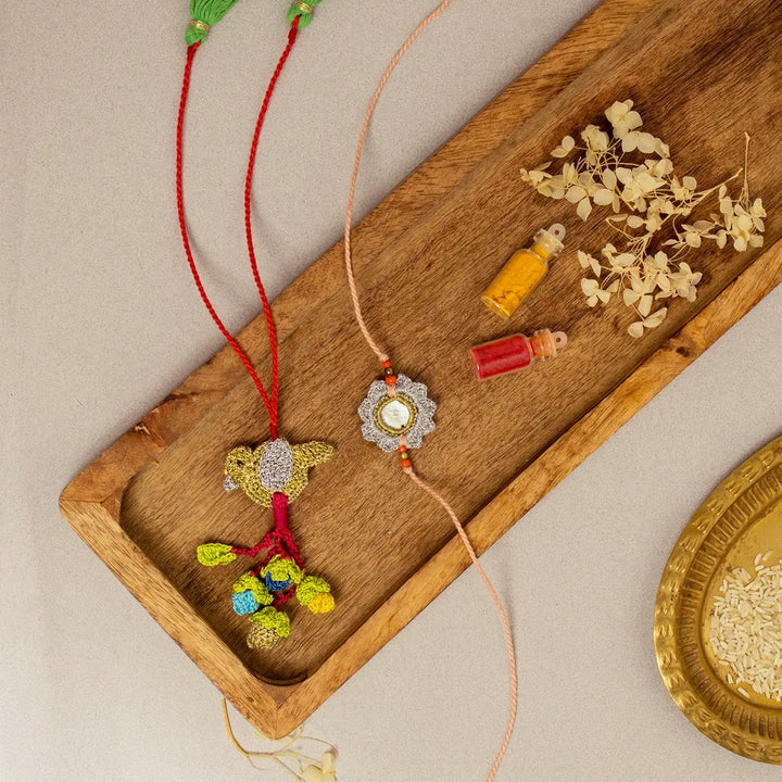 Handmade Crochet Paakhi Seepi Bhaiya Bhabhi Rakhi With Roli Chawal Set Of 2 - Flat Lay with Tray and Plate Combination