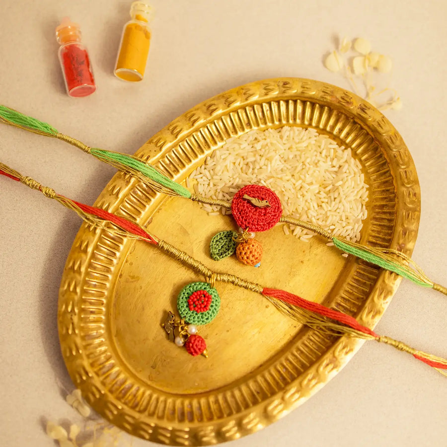 Handmade Crochet Ananya Flower And Golden Bird Rakhi With Roli Chawal Set Of 2 - Front View with Decorative Tray