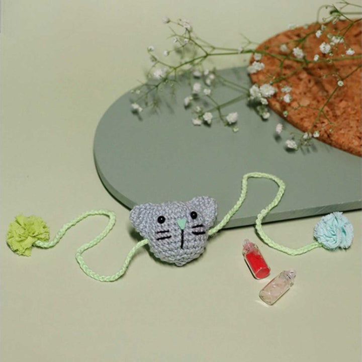 Handmade Crochet Kitty Kisses Kids Rakhi With Roli Chawal - Front View with Styled Background