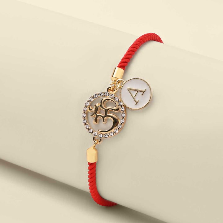 Personalized Handmade Om Design Monogram Metal Rakhi - Bracelet Displayed on Cylindrical Stand