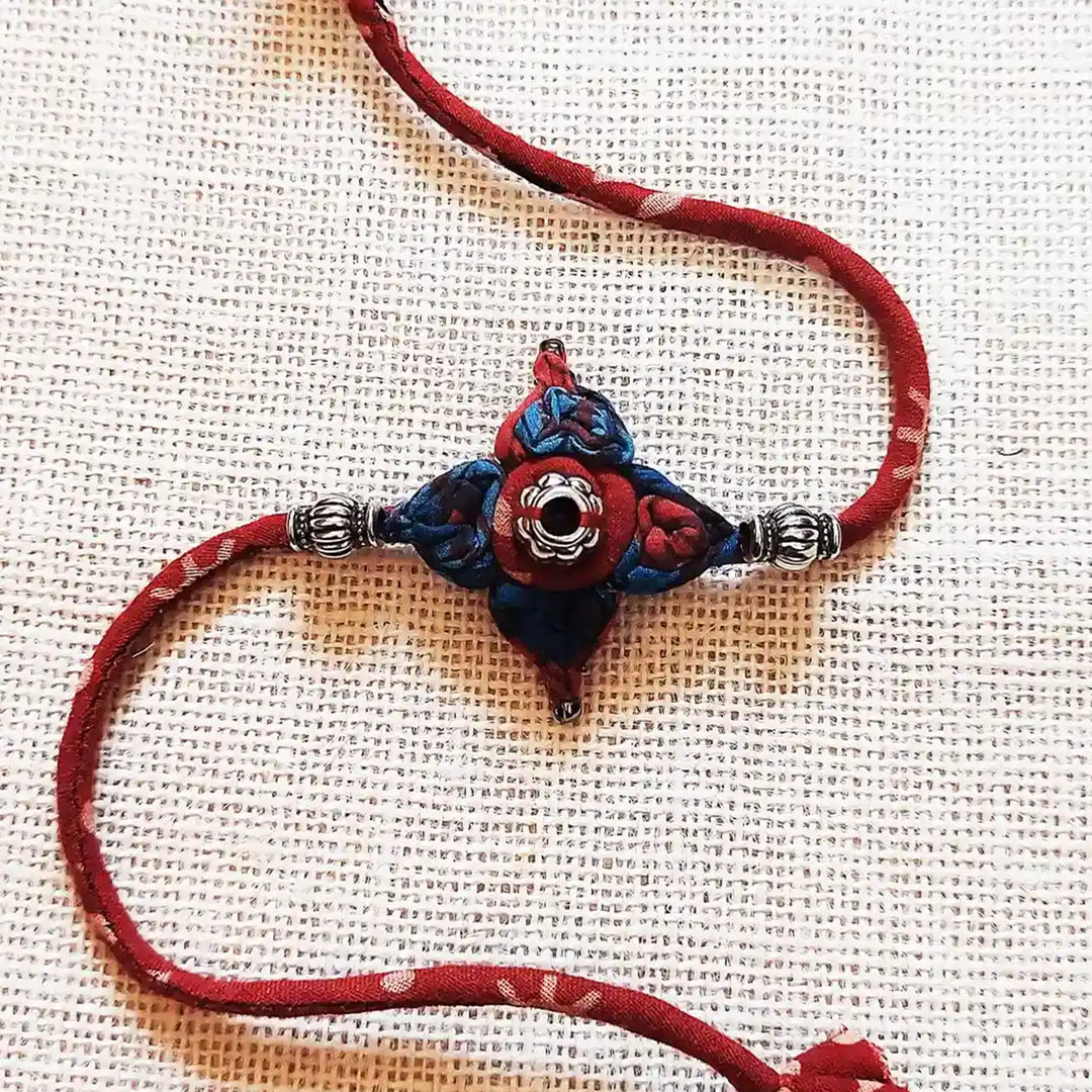 Handmade Dori Work Flower Ajrakh Rakhi With Roli Chawal - Close-up of Central Design