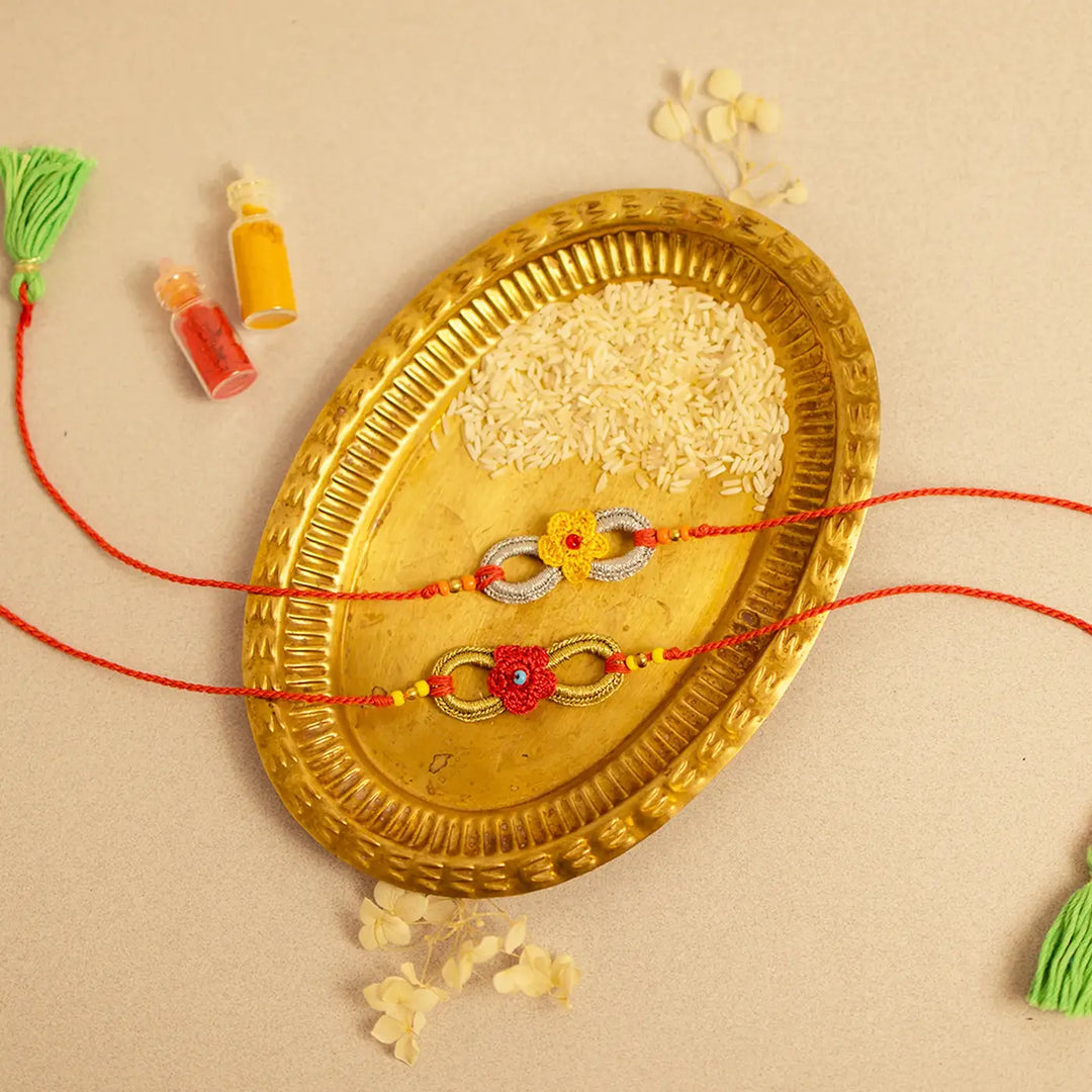 Handmade Crochet Ananta Rakhi With Roli Chawal Set Of 2 1 - Diagonal flat lay display