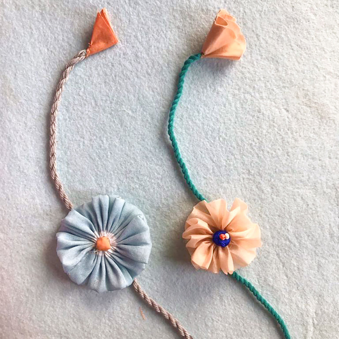Handmade Beaded Daisy Flower Design Upcycled Fabric Rakhi With Roli Chawal For Brother - Two Floral Knot Bands Displayed