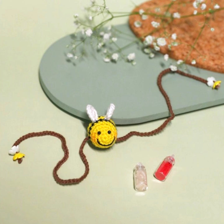 Handmade Crochet Honeybee Kids Rakhi With Roli Chawal - Flat Lay Display