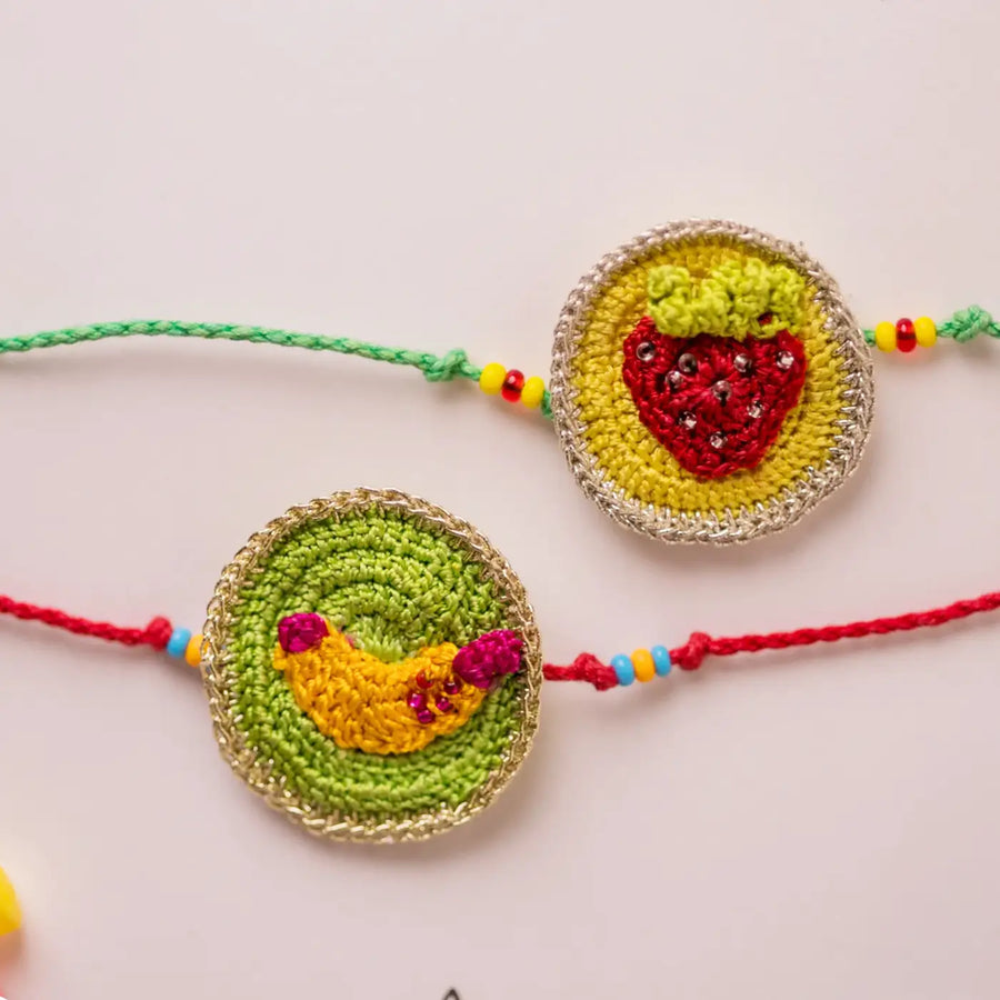 Handmade Crochet Banana And Strawberry Theme Kids Rakhi With Roli Chawal Set Of 2 - Close-up of fruit designs