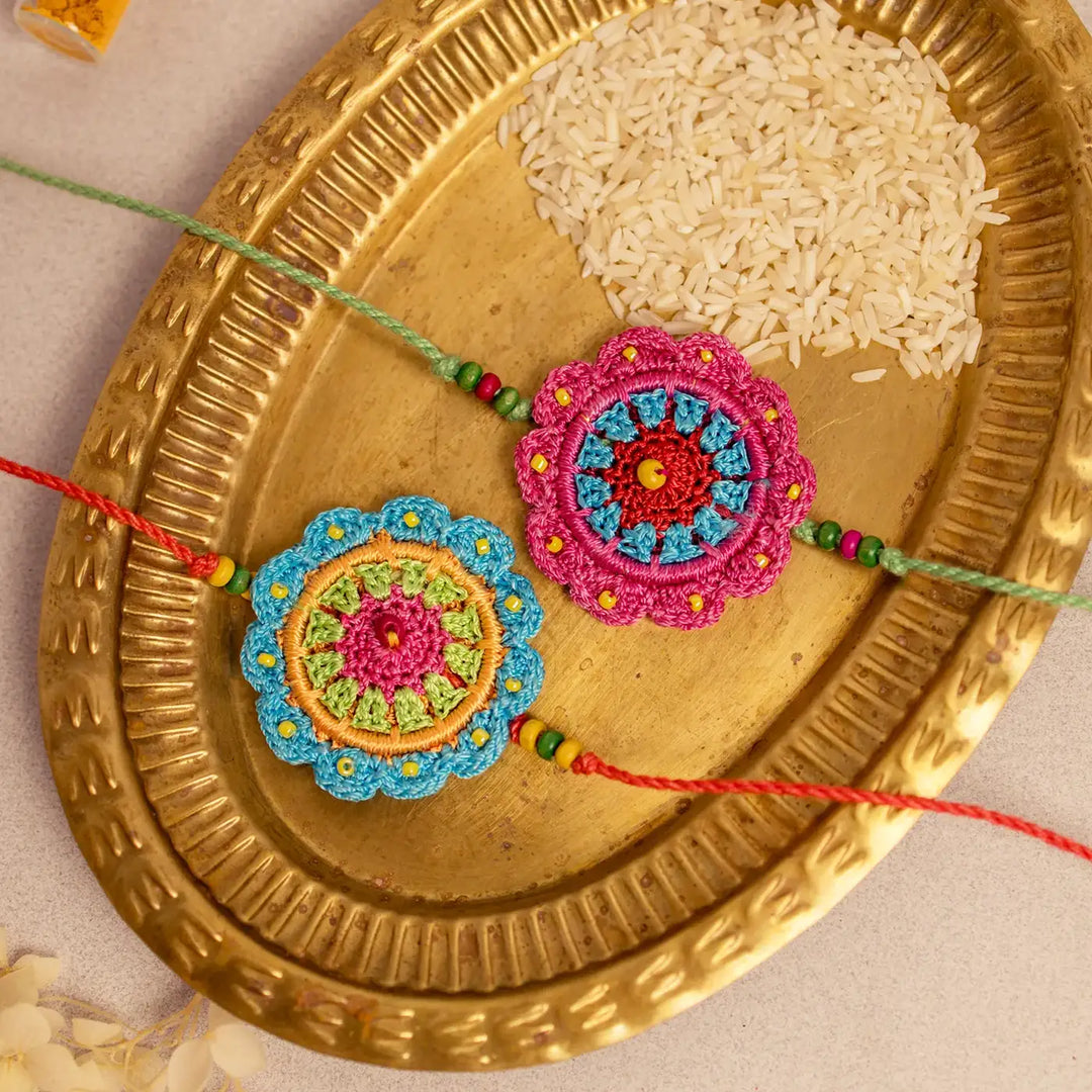 Handmade Crochet Floral Noor Rakhi With Roli Chawal Set Of 2 - Close-up of Crochet Rakhi Pair