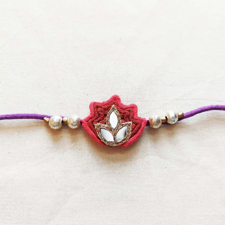 Handmade Mirror Work Lotus Rakhi With Roli Chawal - Close-up of Floral Centerpiece