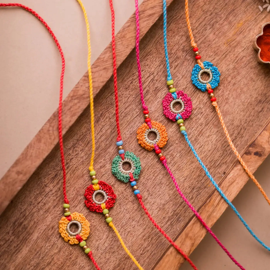 Handmade Crochet Rainbow Flowers Rakhi With Roli Chawal Set Of 6 - Close-up Top View on Tray