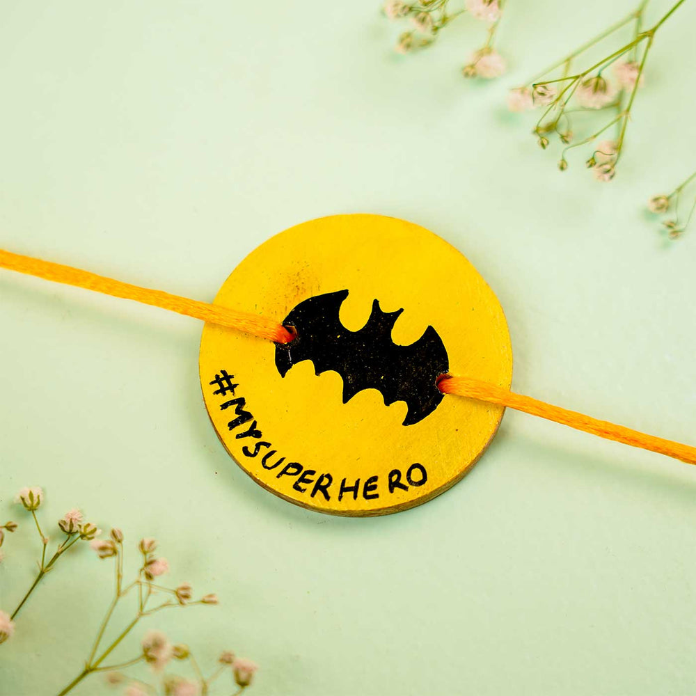 Personalized Hand Painted Batman Wooden Rakhi With Roli Chawal - Flat Lay with Decorative Flowers