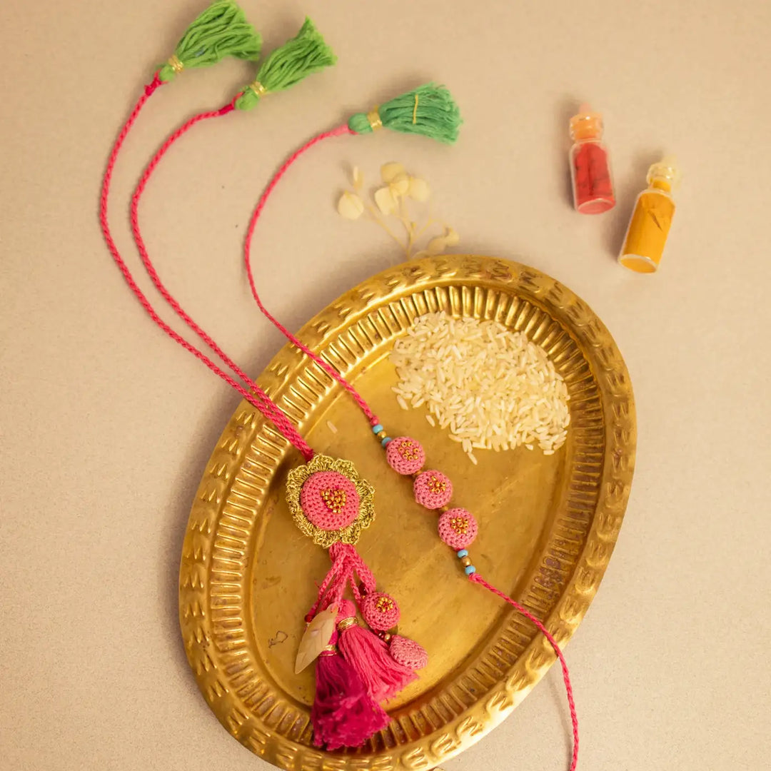Handmade Crochet Gulabi Jhalar Bhaiya Bhabhi Rakhi With Roli Chawal Set Of 2 - Styled on Decorative Tray