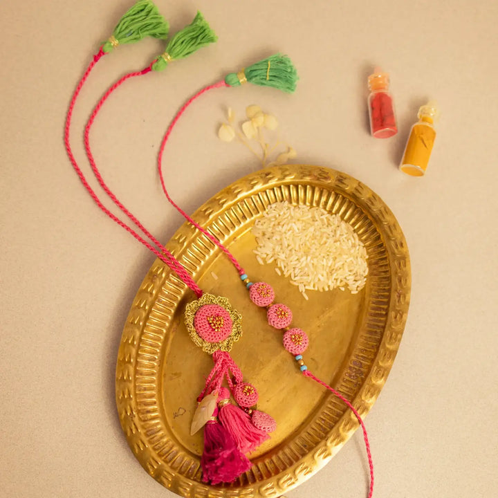 Handmade Crochet Gulabi Jhalar Bhaiya Bhabhi Rakhi With Roli Chawal Set Of 2 - Styled on Decorative Tray