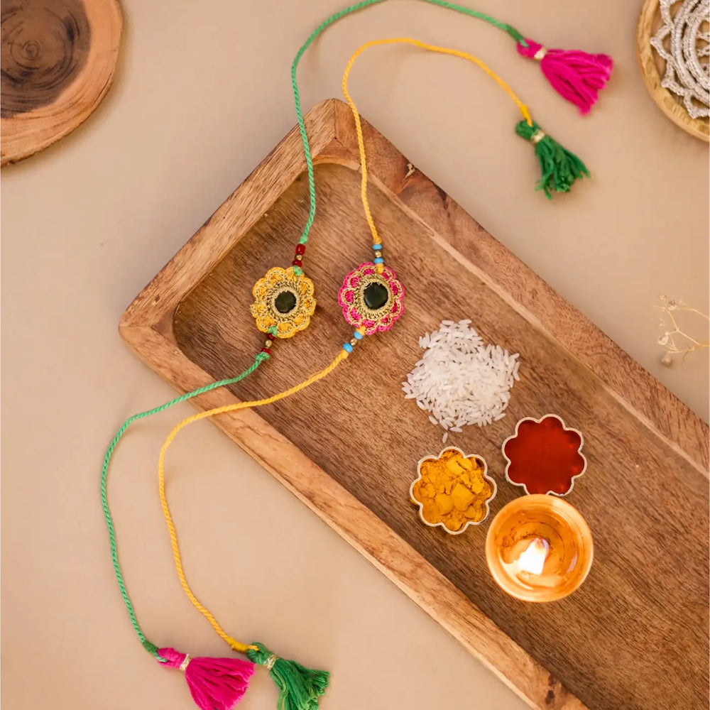 Handmade Crochet Green And Red Kundan Rakhi With Roli Chawal Set Of 2 - Styled with traditional ritual items