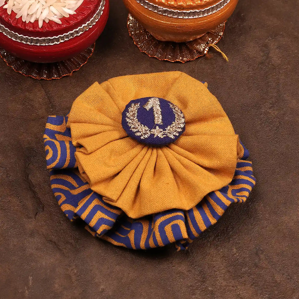 Handmade Blue And Yellow Number One Rakhi With Roli Chawal For Pets - Angled Top View with Props