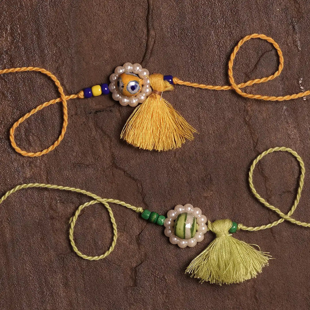 Handmade Blue Pottery Bead With Tassel Rakhi With Roli Chawal Set Of 2 - Close-up on Stone and Tassel