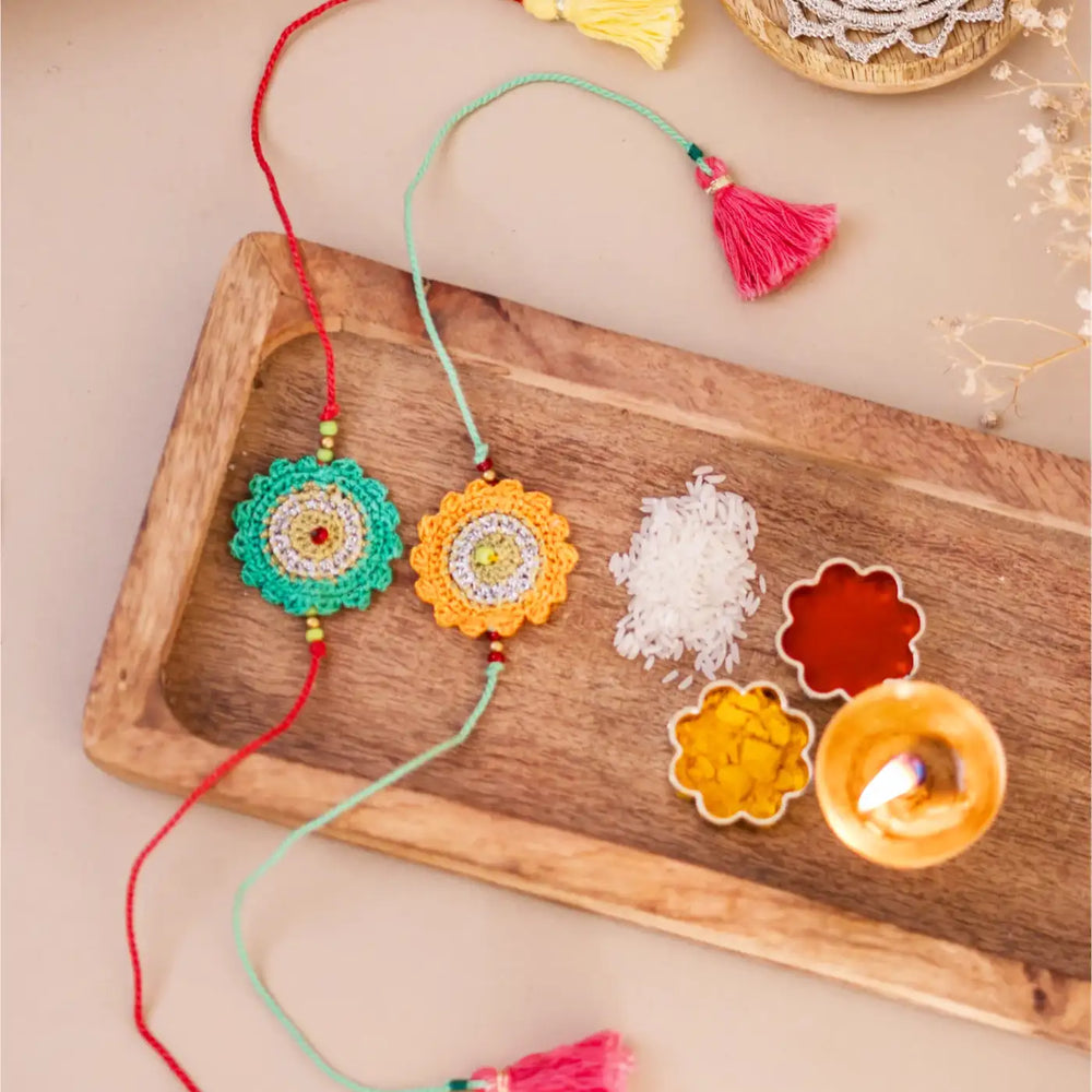 Handmade Crochet Green And Yellow Seher Rakhi With Roli Chawal Set Of 2 - Full View with Festival Elements