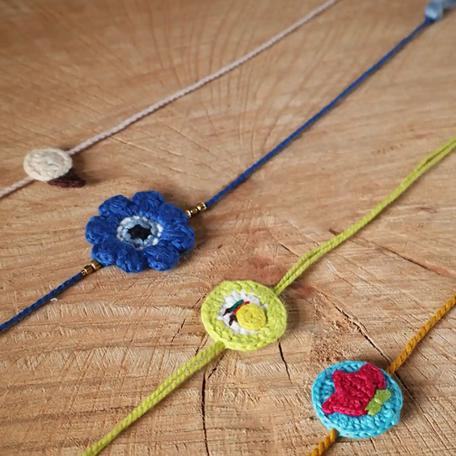 Handmade Crochet Evil Eye Lemon Strawberry Ice Cream Rakhi With Roli Chawal Set Of 4 - Close-up of Bracelets Arrangement