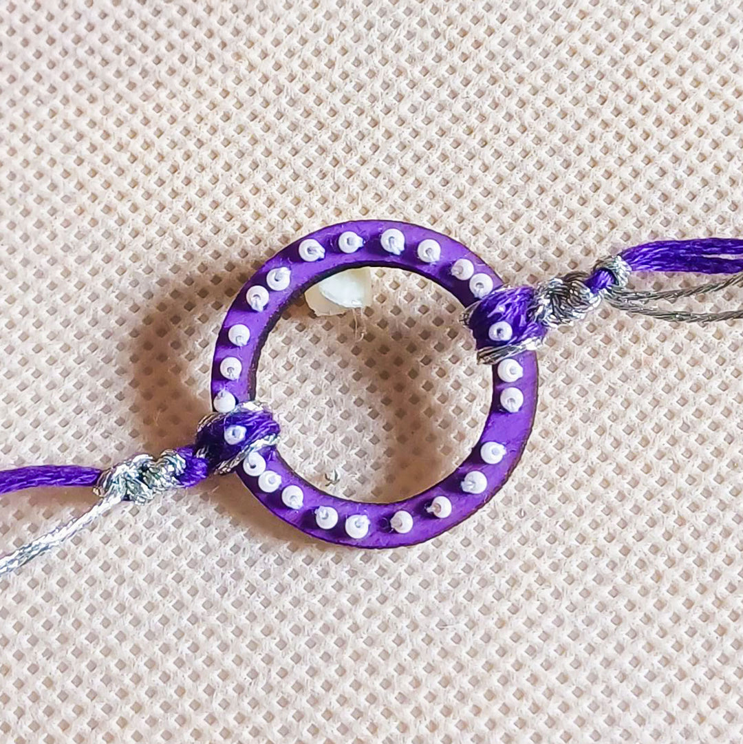 Handmade Round Beads Wooden Rakhi With Roli Chawal For Brother - Close-up of Purple Bracelet Center