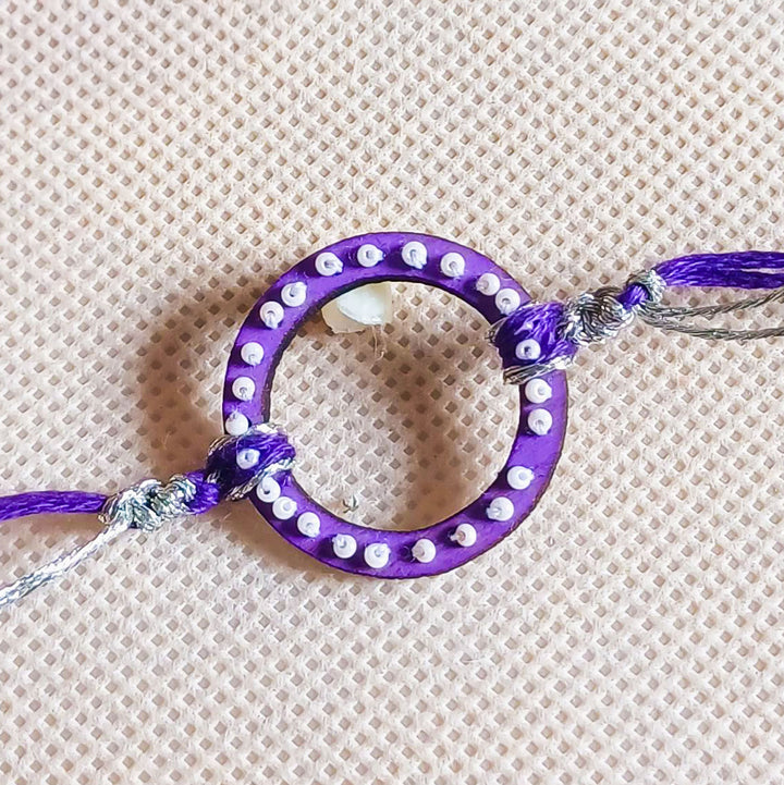 Handmade Round Beads Wooden Rakhi With Roli Chawal For Brother - Close-up of Purple Bracelet Center