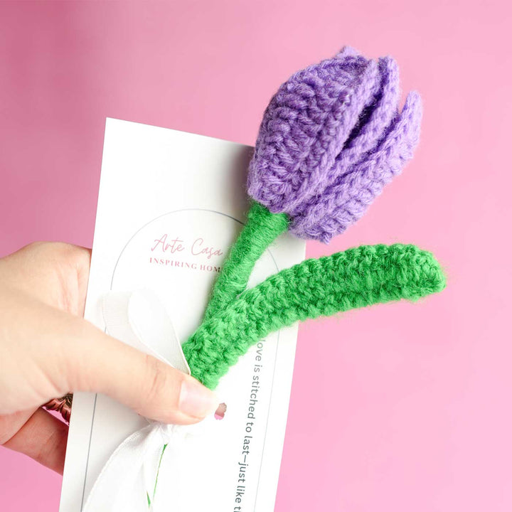 Personalized Handmade Crochet Tulip Dark Purple Rakhi Hamper Includes 1 Crochet Flower 1 Message Card And 2 Rakhis And Roli Chawal - Close-up Hand Holding Product