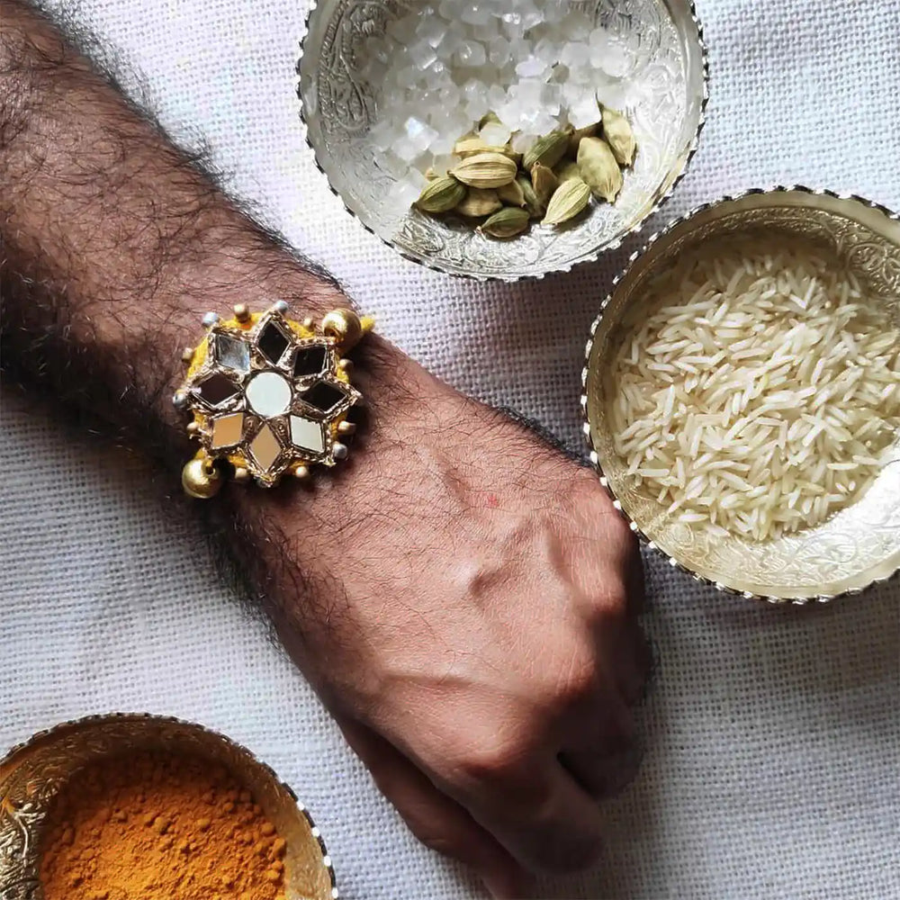 Handmade Beaded Mirror Work Rakhi With Roli Chawal - Worn on wrist with props
