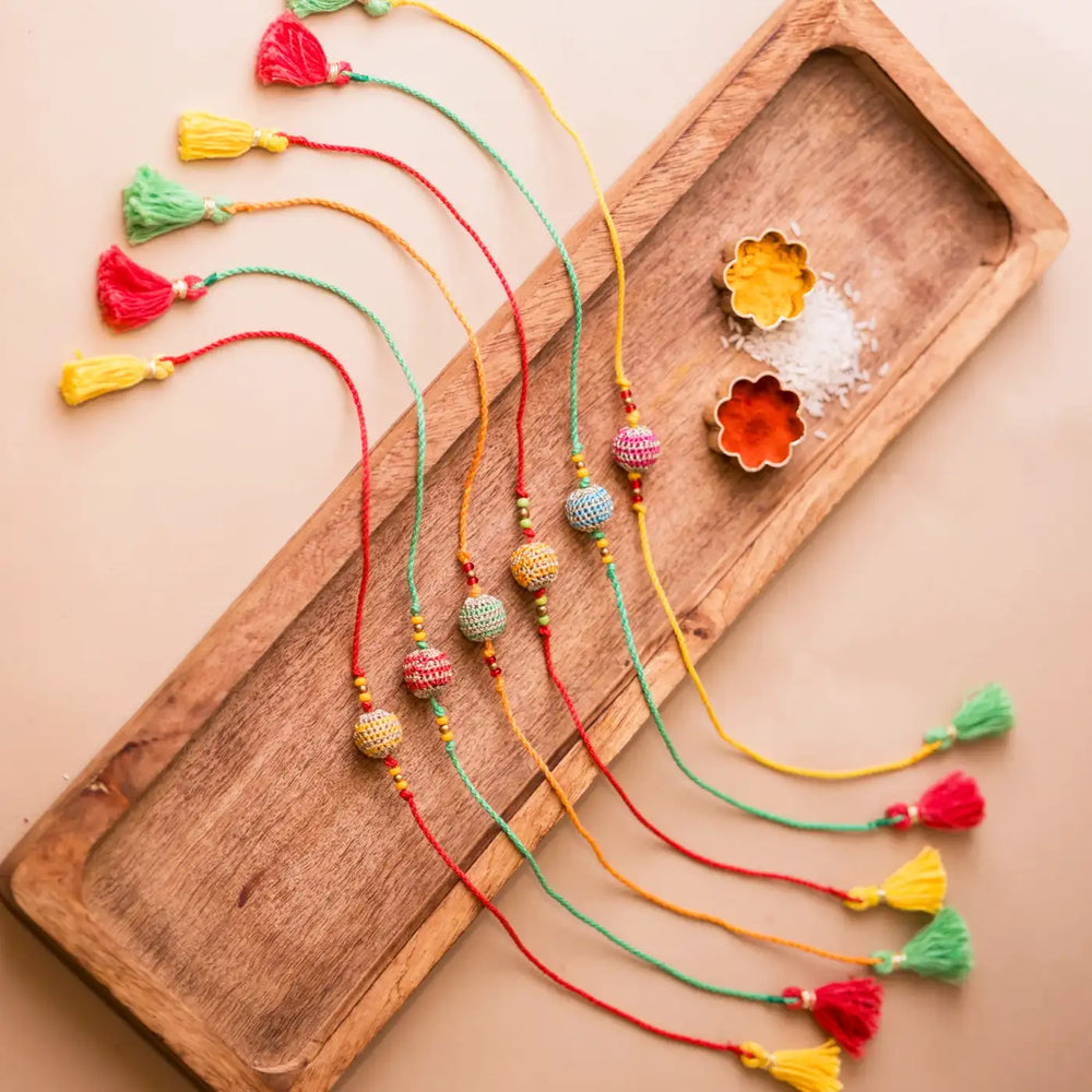 Handmade Crochet Multicolour Lined Suraj Rakhi With Roli Chawal Set Of 6 - Full layout with spices