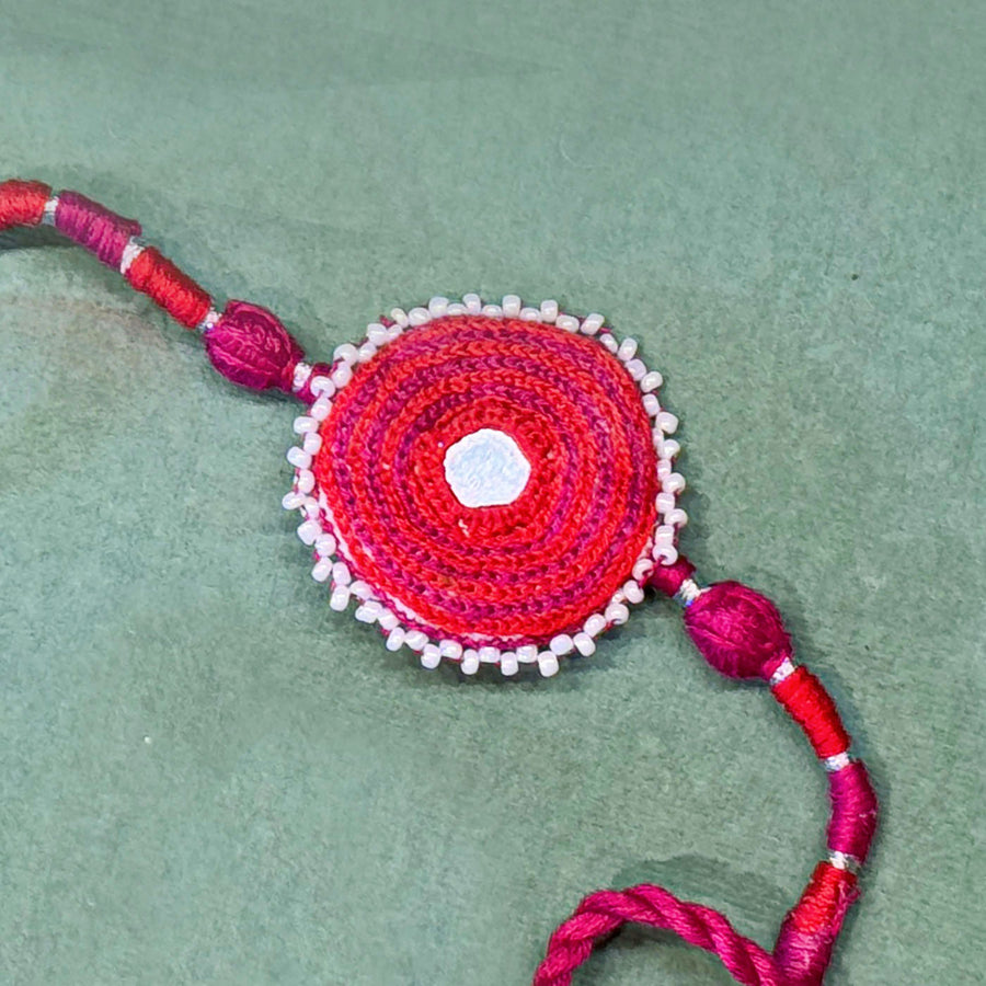 Handmade Reusable Pink Patwa Ari Mirror And Potli Rakhi For Brother - Close-up of Circular Textile Detail