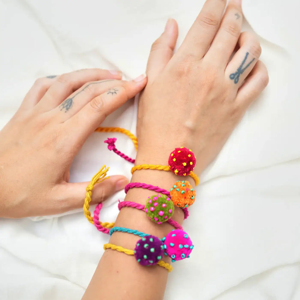 Handmade Beaded Pom Pom Mini Laddoo Rakhi With Roli Chawal Set Of 5 - Top view of bracelets on wrist