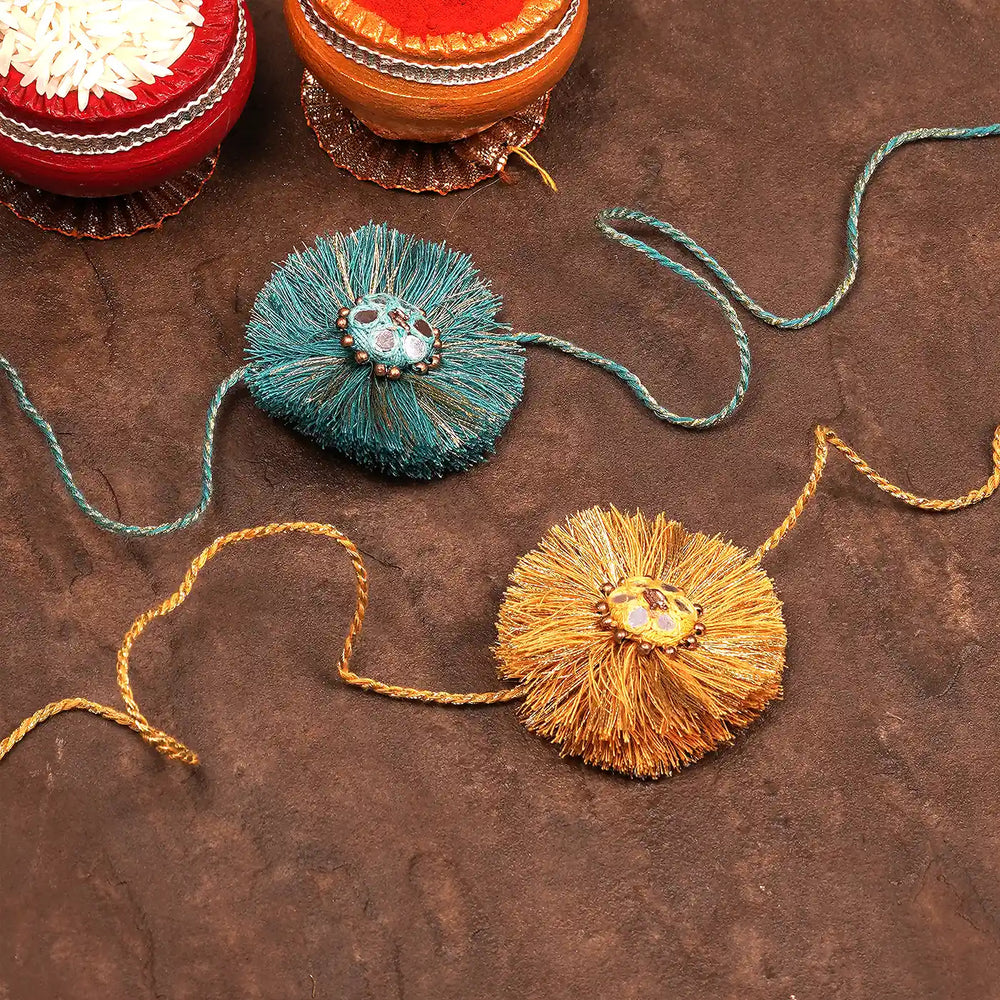 Handmade Mirror Work Blue And Yellow Rakhi With Roli Chawal Set Of 2 - With Festival Items in Background